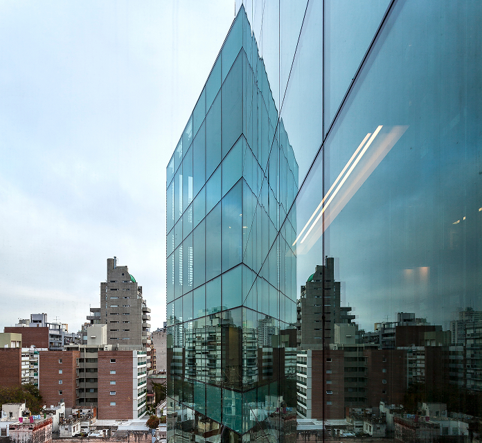 Edificio de vidrio moderno reflejando el paisaje urbano